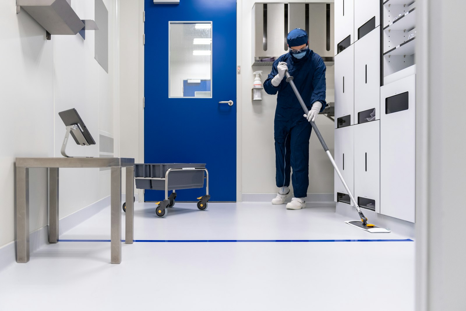 Cleaning professional mopping a bright facility corridor